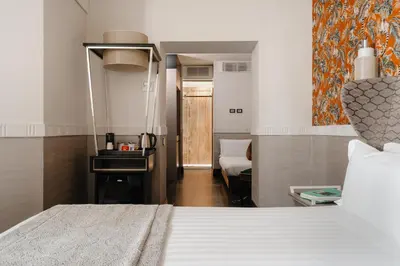 a hotel room with a bed and a bathroom at Unica Suites Rome in Rome