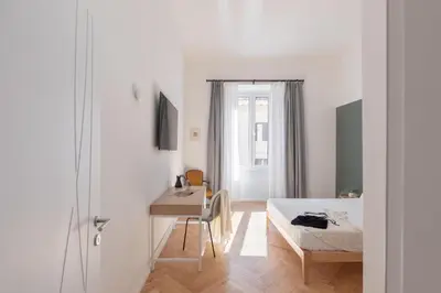 a bedroom with a bed and a table and a desk at iFlat The Sweet Life in Rome in Rome