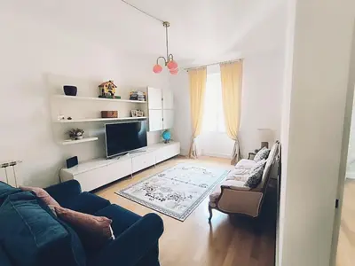a living room with a blue couch and a tv at Elegant apartment 5 minutes from the subway in Rome