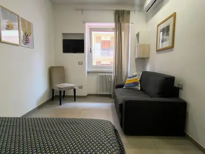 a bedroom with a couch and a chair in a room at Casa di Eu - WelcomeToRhome in Rome