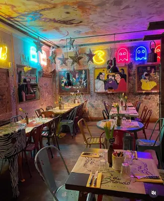 a restaurant with tables and chairs with neon lights at Da Brando Loft PONTE MILVIO in Rome