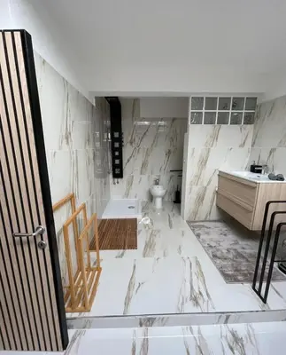 a bathroom with white marble walls and a sink at Da Brando Loft PONTE MILVIO in Rome