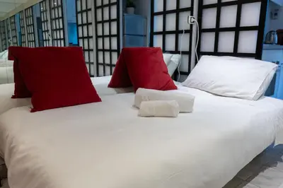 a bed with red and white pillows on it at San Pietro Apartment Vatican 5 min Walk in Rome