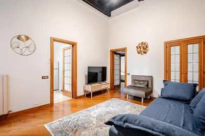 a living room with a blue couch and a tv at Eleganza e charme a due passi da Piazza di Spagna in Rome