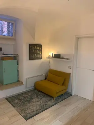 a yellow chair in a living room with a window at PIRAMIDE apartment in Rome