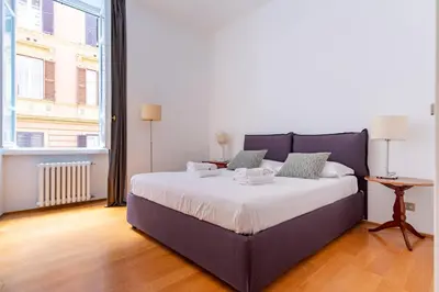 a bedroom with a large bed and a large window at Elegantis Ten windows on Trastevere in Rome