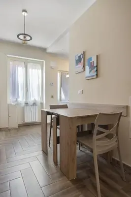 a dining room with a wooden table and a chair at Conca D'Oro Guest House - Stefania in Rome