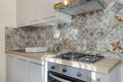 a kitchen with a stove and a tile wall at Conca D'Oro Guest House - Stefania in Rome