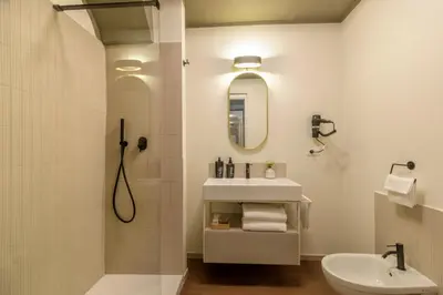 a bathroom with a shower and a sink and a mirror at Urban Garden Suites in Rome