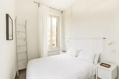 a white bedroom with a white bed and a window at Panorama Home in Rome