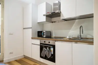 a kitchen with white cabinets and a sink at Monolocale moderno a 2 min dalla metro B in Rome
