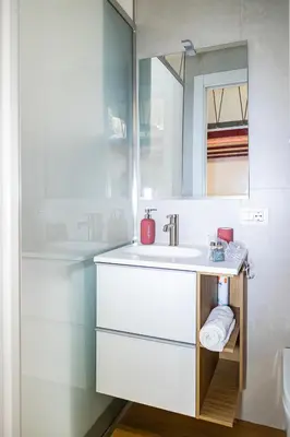 a white bathroom with a sink and a mirror at Monolocale moderno a 2 min dalla metro B in Rome