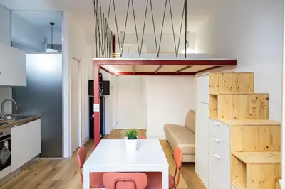 a small apartment with a white table and pink chairs at Monolocale moderno a 2 min dalla metro B in Rome