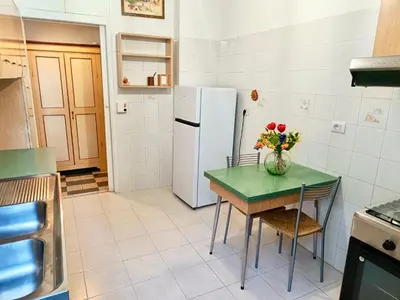 a kitchen with a table with a vase of flowers on it at Flaminio Charme in Rome
