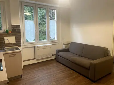 a living room with a couch and a kitchen at Dream Forest in Rome