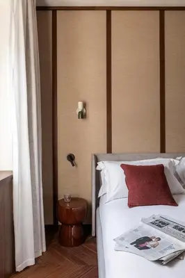 a hotel room with a bed with a newspaper on it at NAMAN HOTELLERIE - Roma in Rome