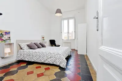 a white room with a bed and a chair at Le Rondinelle di Trastevere in Rome