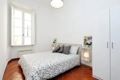 a white bedroom with a bed and a window at Le Rondinelle di Trastevere in Rome
