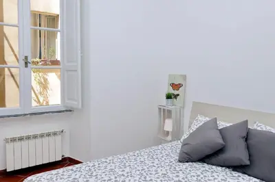 a white bedroom with a bed and a window at Le Rondinelle di Trastevere in Rome