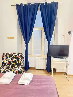 a bedroom with a bed and a blue curtain at Miniapartment in the center of Rome in Rome