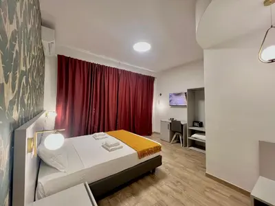 a bedroom with a bed and a red curtain at Qg Golden Rooms in Rome