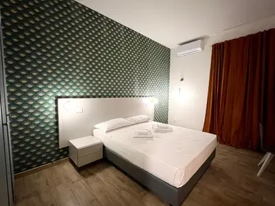 a bedroom with a white bed and a black wall at Qg Golden Rooms in Rome