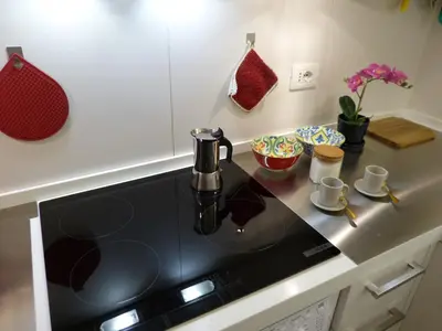 a kitchen with a black counter top with a sink at The column of Campo de' Fiori in Rome
