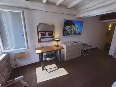 a bedroom with a desk and a mirror and a dresser at The column of Campo de' Fiori in Rome