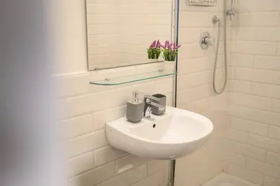 a white bathroom with a sink and a mirror at Lovely apartment in the City Centre in Rome