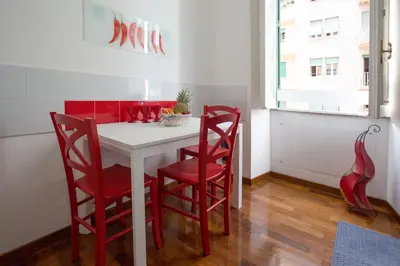 a dining room with red chairs and a white table at Roma San Peter Suite in Rome