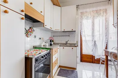 a kitchen with white cabinets and a stove top oven at Karolina's Home, 2-BDR at Vatican in Rome