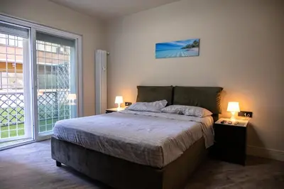 a bedroom with a bed with two lamps and a window at zampieri house camera blu in Rome