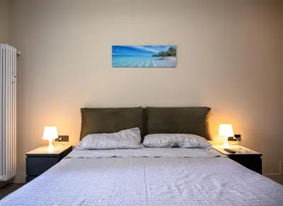 a bedroom with a bed with two lamps on both sides at zampieri house camera blu in Rome