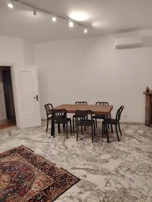 a table and chairs in a room with a rug at Anna Roma House 2 in Rome
