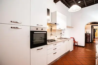a kitchen with white cabinets and a stove top oven at Persia Collection Ripetta in Rome