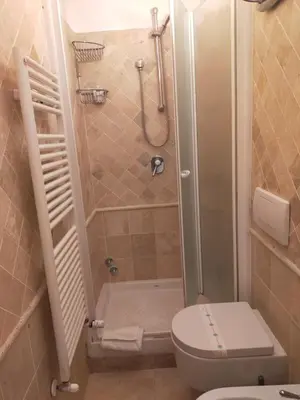a small bathroom with a toilet and a shower at Charming Trastevere Sun in Rome