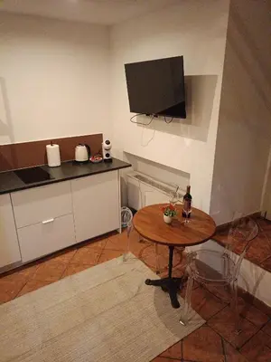 a kitchen with a table and a tv on the wall at Charming Trastevere Sun in Rome