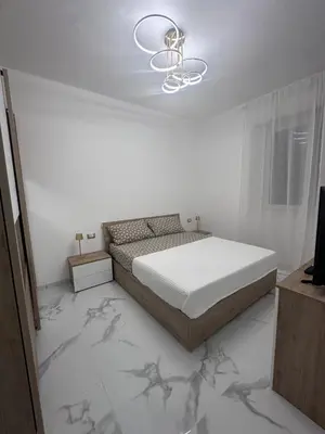 a white bedroom with a bed and a chandelier at Rome s finest in Rome