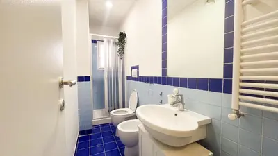 a blue and white bathroom with a sink and a toilet at La casa dell'artista in Rome