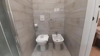 a white bathroom with a toilet and a sink at Vatican Rooms Cipro 2 in Rome