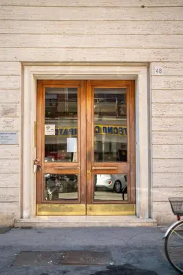 a door of a building with a reflection of a bus at Les Maisons De Thomas Vaticano in Rome