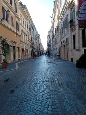 a cobble stone street in a city with buildings at Roman Babuino Inn in Rome