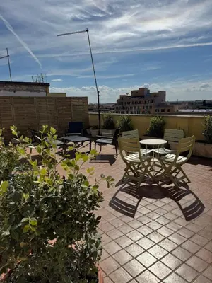 a patio with two chairs and a table on a roof at La Casa di Bru - Cinque Camere - Dieci posti - Terrazzo in Rome