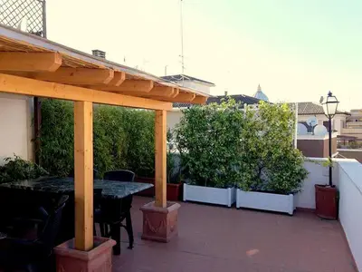 a patio with a wooden pergola and a table and chairs at Attico 203 in Rome