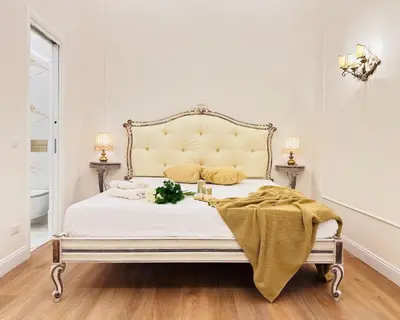 a white bedroom with a bed with a yellow blanket on it at Trevi Fountain Elegant Suites by Marianna in Rome