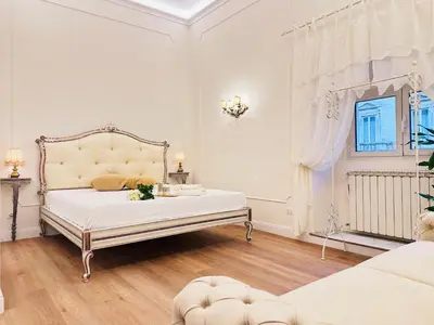 a white bedroom with a bed and a window at Trevi Fountain Elegant Suites by Marianna in Rome