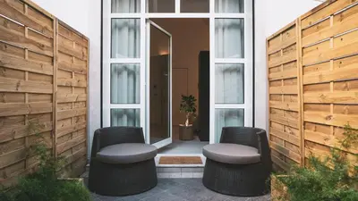 a patio with two wicker chairs and a mirror at Morin 10 Rome Exclusive Suites in Rome
