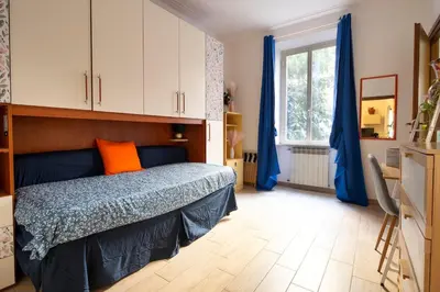 a bedroom with a bed with blue and orange pillows at Holiday Season in Rome