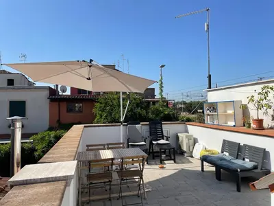 a patio with a table and chairs and an umbrella at Cozy house with terrace in Rome