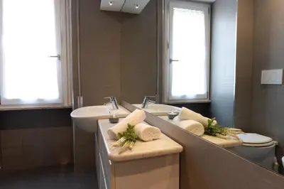 a bathroom with a sink and a toilet and a mirror at Apartment Casa Girina Boutique in Rome